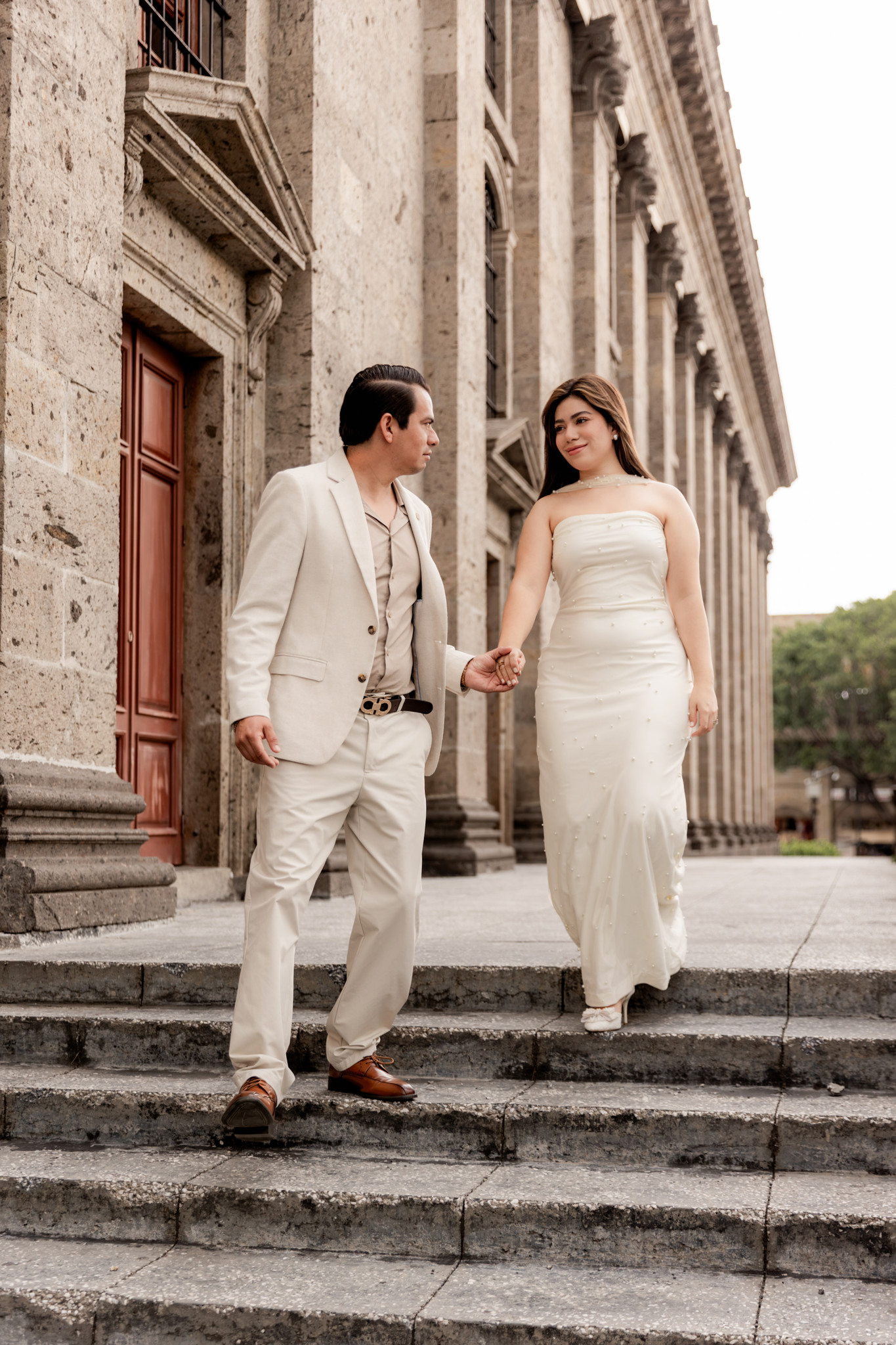 Miradas y risas de la pareja frente al ícono arquitectónico tapatío