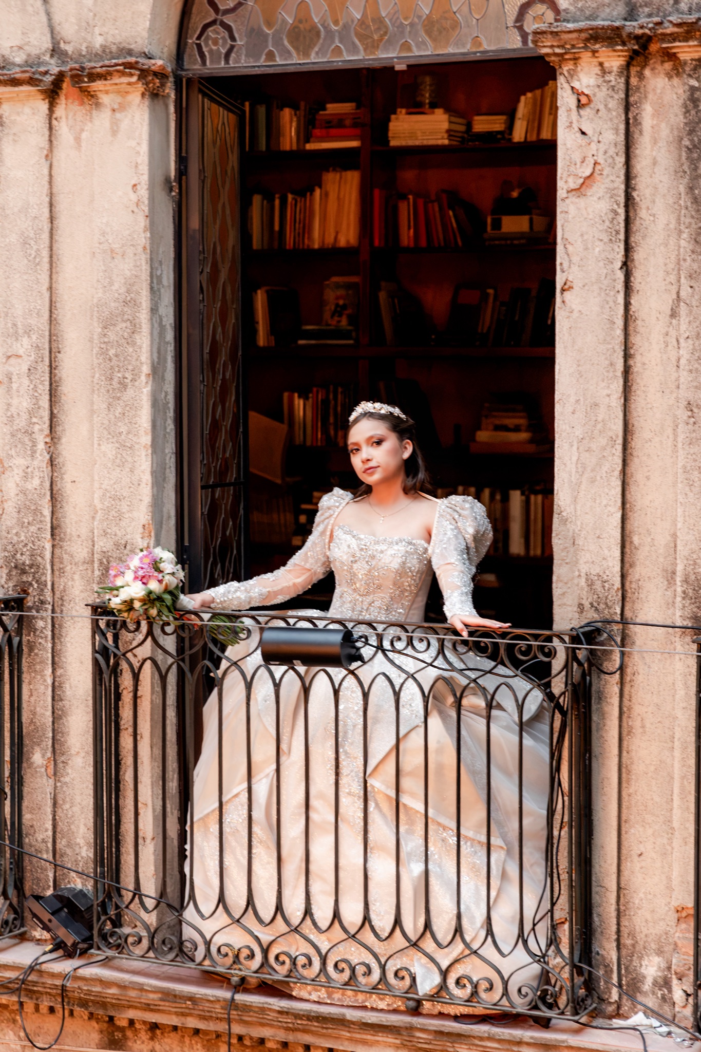 Karol en el balcón de herrería, con la biblioteca del palacio detrás de ella