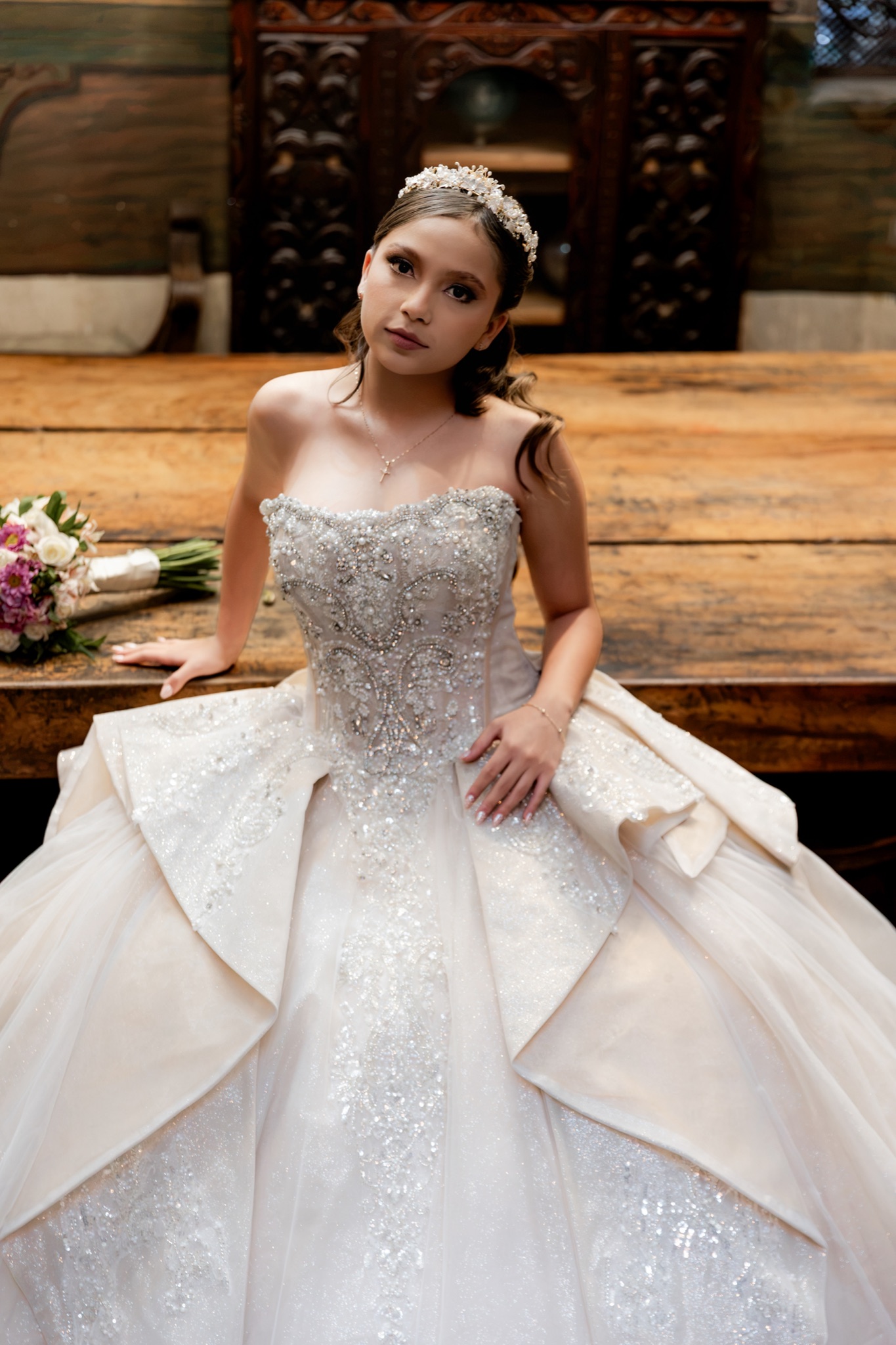 Retrato de Karol con su tiara y vestido de pedrería, sentada en la mesa de madera del palacio